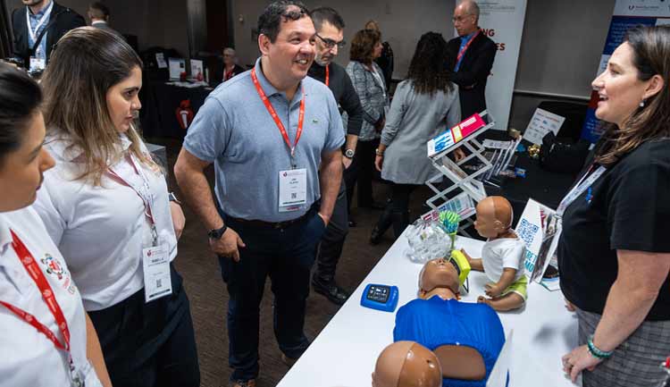 An exhibitor of CPR products talks with meeting attendees.