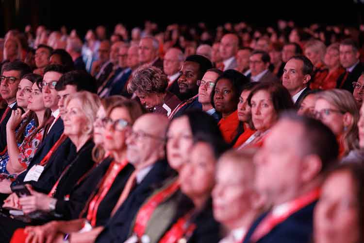 #AHA25 attendees watch a main event presentation.