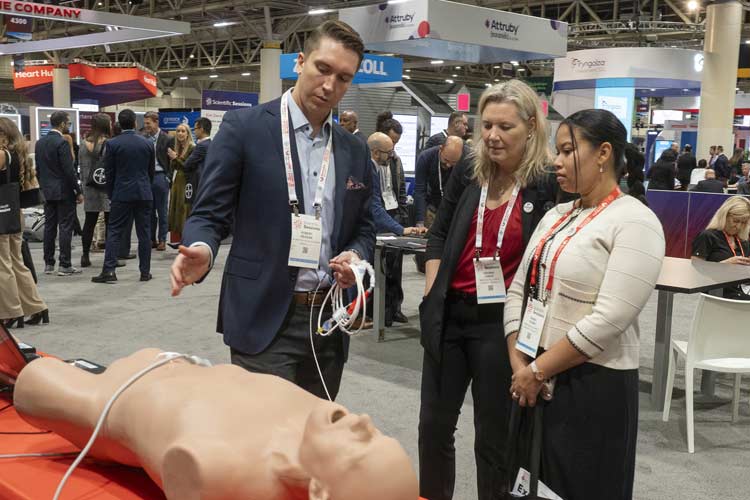 Scientific Sessions attendees speak with an exhibitor about their product.