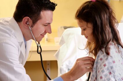 doctor listening to girls heartbeat