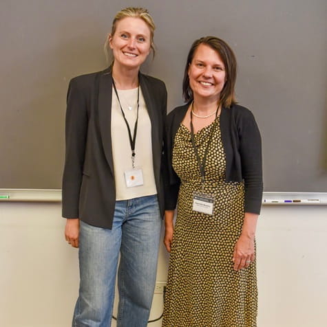 Dr. Dinu and Dr. Beasley standing, facing camera with a chalkboard behind them