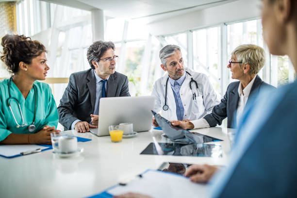 Image of doctors sitting around a table, in a discussion (Getty Image 1153847290)