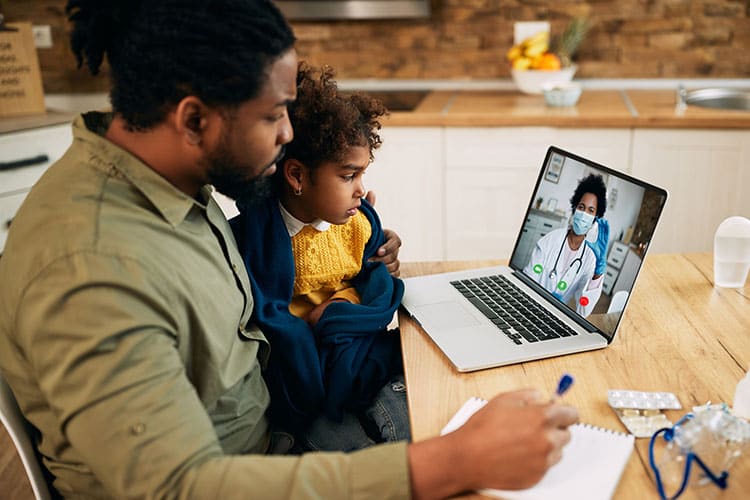  African American father and daughter having video call with family doctor