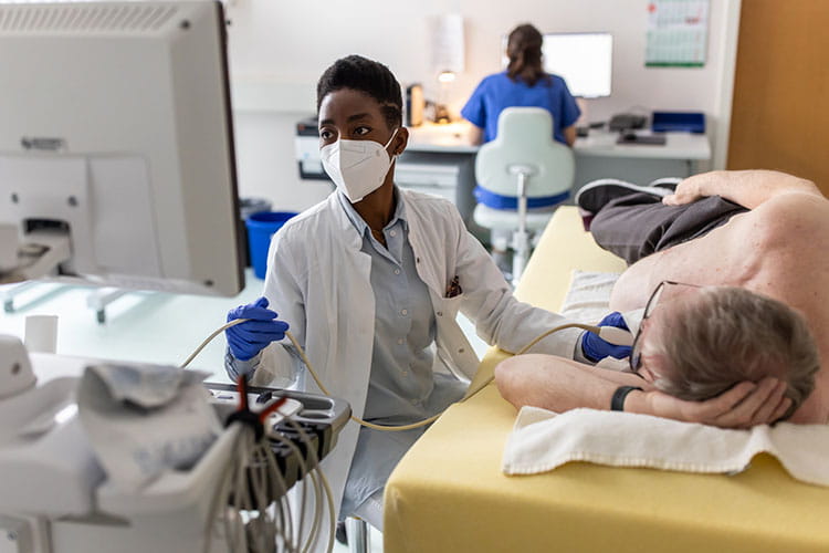  Cardiologist doing echocardiogram test of a senior male patient in heart clinic