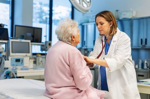 doctor listening to senior woman's breathing