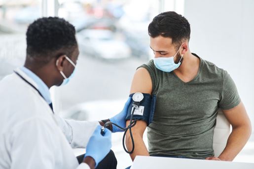 Young, male doctor checking the blood pressure of a male patient