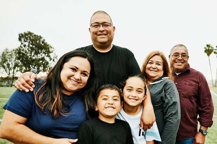 Portrait of multigenerational family on field after daughters' soccer game 