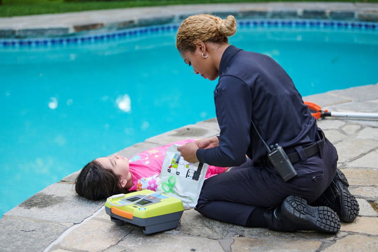 paramedic attending child near swimming pool