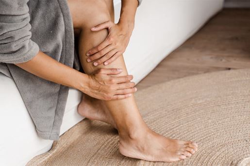 woman touching legs and looking at veins