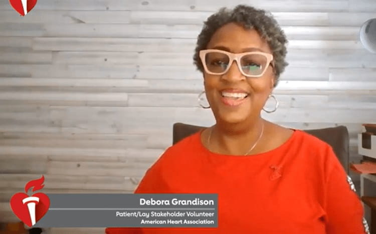 Woman wearing red shirt and red eyeglasses sitting behind a desk